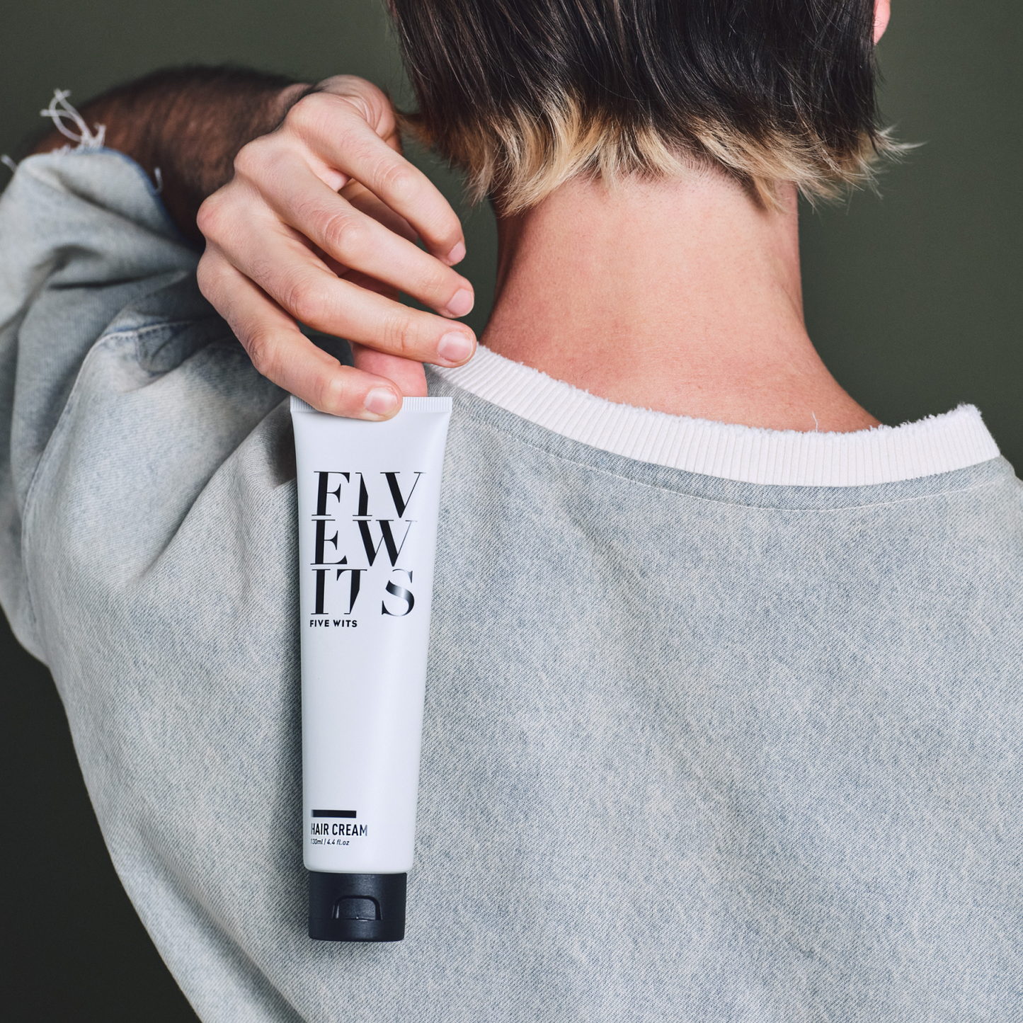 Man holding Five wits hair cream product