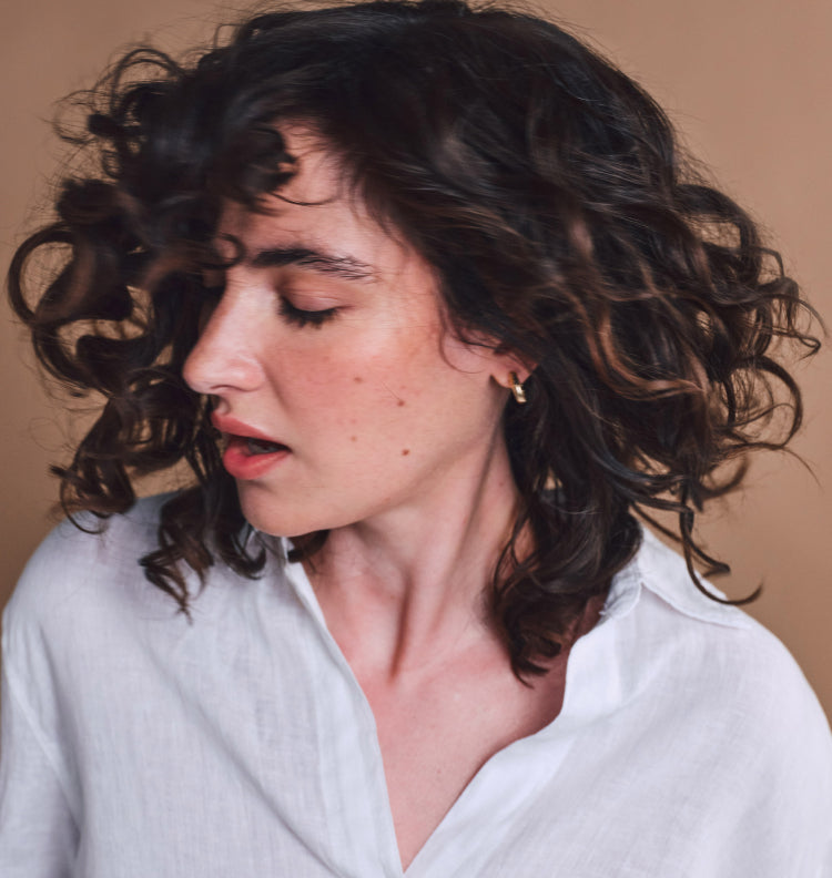 woman shaking head w long wavy hair