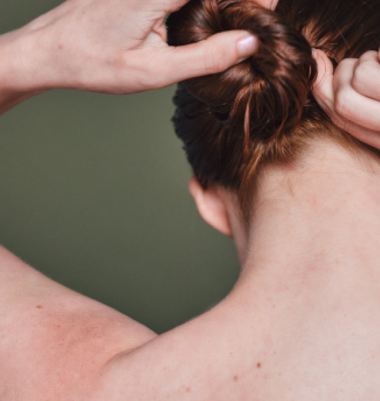Close up of woman putting hair in bun
