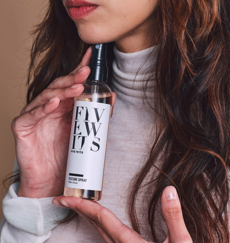 woman holding Five Wits Texture Spray under chin