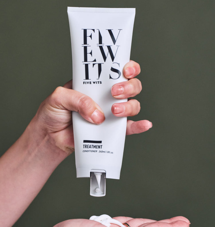 hand squeezing Five Wits Treatment conditioner bottle