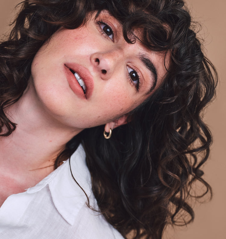 woman tipping head to side with curly hairstyle